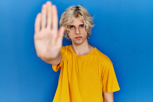 Joven Hombre Moderno Pie Sobre Fondo Azul Haciendo Dejar Cantar —  Fotos de Stock