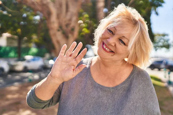 Mujer Rubia Mediana Edad Sonriendo Confiada Diciendo Hola Parque —  Fotos de Stock