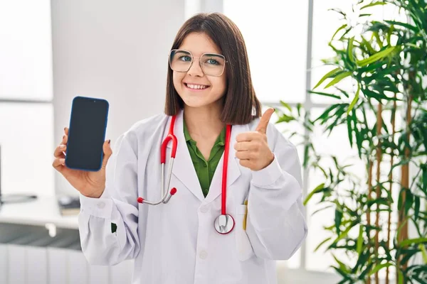 Mladý Hispánský Lékař Žena Ukazující Smartphone Obrazovka Úsměvem Šťastný Pozitivní — Stock fotografie