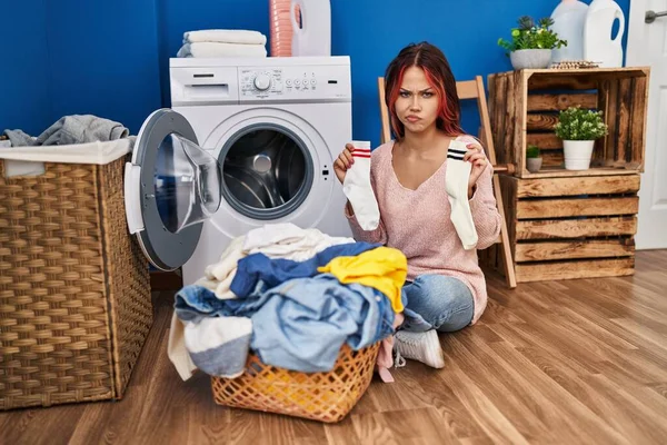 若い白人女性は靴下を懐疑的で緊張して洗濯をしており 問題のために動揺して眉をひそめています 否定的な人 — ストック写真