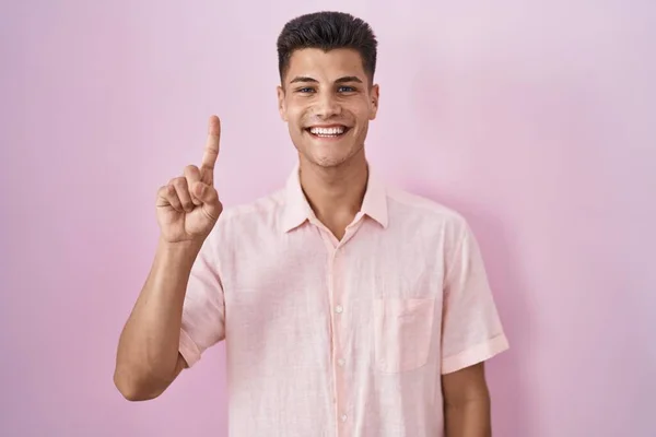 Joven Hombre Hispano Pie Sobre Fondo Rosa Mostrando Señalando Con — Foto de Stock