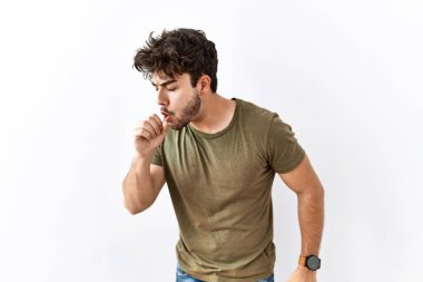 Hispanic man standing over isolated white background feeling unwell and coughing as symptom for cold or bronchitis. health care concept. 