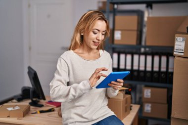 Genç kadın ecommerce busines işçisi ofiste çalışan touchpad kullanıyor.