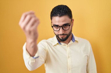 İspanyol genç adam iş kıyafetleri ve gözlük takıyor. İtalyan jestleri yapıyor. Elleri ve parmakları kendine güvenen ifadeler kullanıyor. 