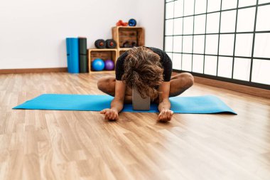 Genç İspanyol sporcu adam spor merkezinde esneme hareketleri yapıyor..