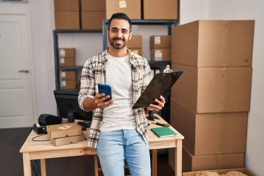 Genç bir İspanyol iş adamı ofisteki akıllı telefon okuma belgesini kullanıyor.