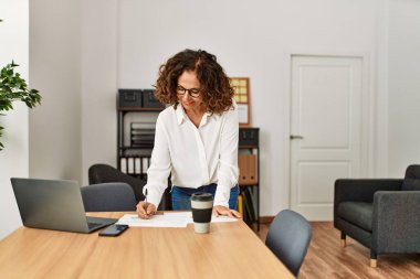 portrait of smiling middle-aged business woman working at office.