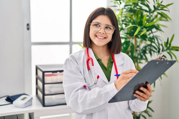 Jovem Bela Mulher Hispânica Médico Sorrindo Confiante Escrever Relatório Médico — Fotografia de Stock