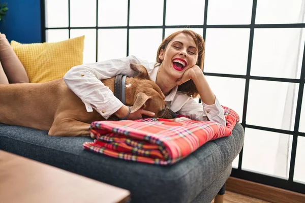 Beyaz Kadın Gülümsüyor Kendine Güvenen Kucaklayan Köpek Evdeki Kanepede Yatıyor — Stok fotoğraf