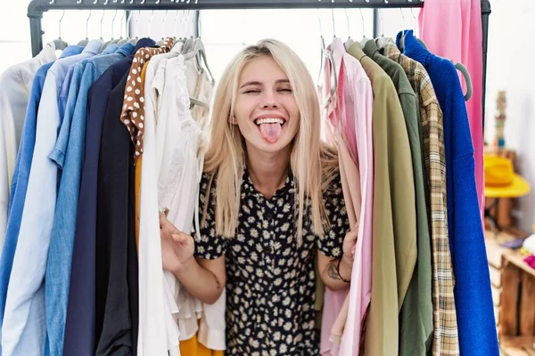 Joven Mujer Rubia Buscando Ropa Perchero Ropa Sacando Lengua Feliz — Foto de Stock