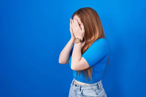 Mujer Pelirroja Pie Sobre Fondo Azul Con Expresión Triste Cubriendo —  Fotos de Stock