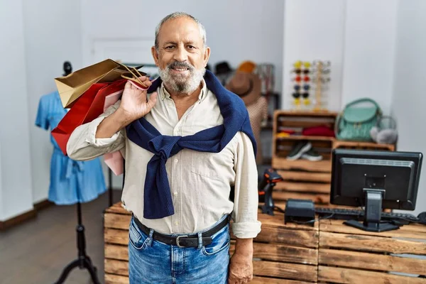 Älterer Grauhaariger Mann Lächelt Selbstbewusst Und Hält Einkaufstüten Bekleidungsgeschäft — Stockfoto