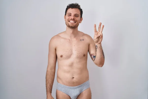 Ung Latinamerikansk Man Står Tröjlös Klädd Underkläder Visar Och Pekar — Stockfoto