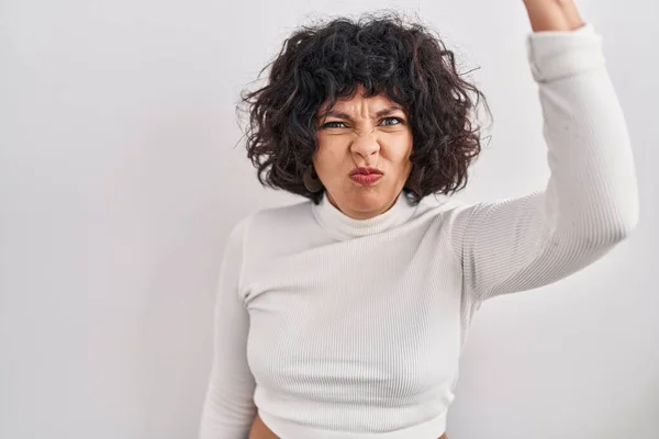 怒りで叫んでいる間 孤立した背景に立っている巻き毛のあるヒスパニック系の女性は怒って怒って拳を上げ 激怒しました 怒りと攻撃的な考え方 — ストック写真