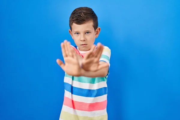 Młody Biały Dzieciak Stojący Nad Niebieskim Tle Odrzucenie Wyrażenie Skrzyżowanie — Zdjęcie stockowe