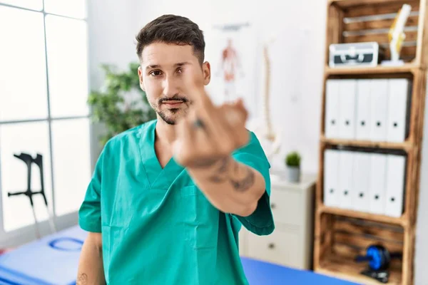 Young Physiotherapist Man Working Pain Recovery Clinic Showing Middle Finger — Stockfoto