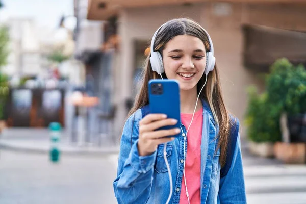 ストリートで音楽を聴く愛らしい女の子学生 — ストック写真