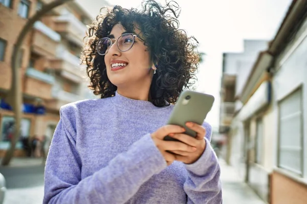 Young middle east woman smiling confident using smartphone at street