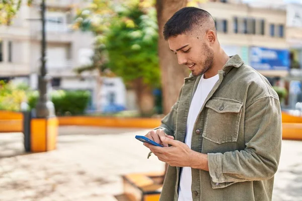 Jonge Spaanse Man Glimlacht Vol Vertrouwen Met Smartphone Het Park — Stockfoto