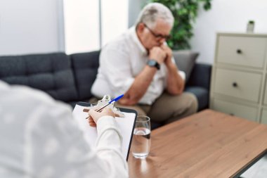 Orta yaşlı, kır saçlı bir adam psikoloji kliniğinde psikoloji seansı yapıyor.