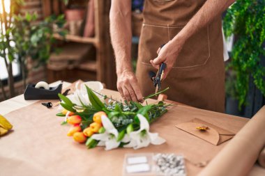 Çiçekçinin sapını kesen genç sarışın adam.