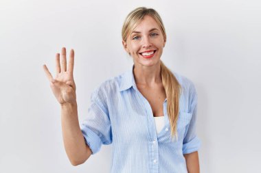 Beautiful blonde woman standing over white background showing and pointing up with fingers number four while smiling confident and happy. 