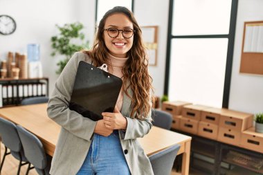 Genç, güzel, İspanyol bir kadın. İş işçisi. Elinde bir pano var.