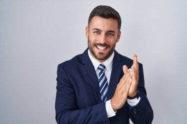 Yakışıklı İspanyol takım elbiseli ve kravatlı adam alkışlıyor ve mutlu, neşeli ve gururlu elleri alkışlıyor. 