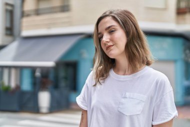 Sokakta duran rahat yüzlü genç kadın.