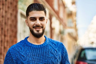 Sokakta kendinden emin gülümseyen genç bir Arap.