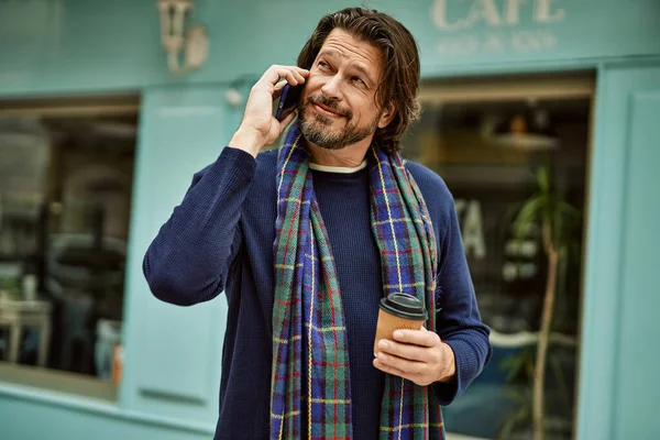 Middle age handsome man speaking on the phone at the town