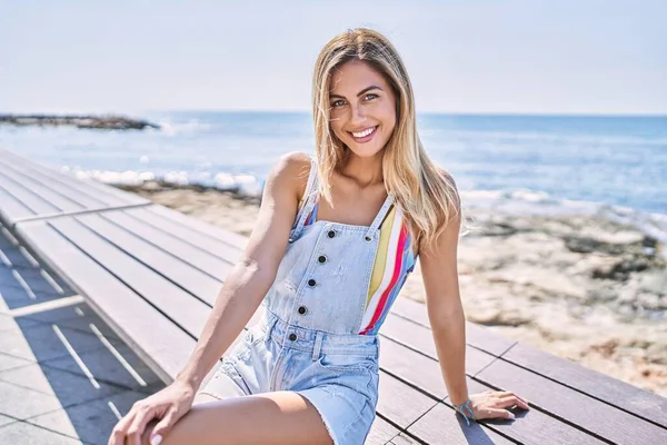 Mladý Blondýnka Dívka Usměvavý Šťastný Sedí Lavičce Pláži — Stock fotografie