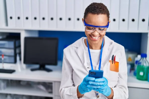 アフリカ系アメリカ人女性科学者が自信を持って笑顔で研究室でスマートフォンを — ストック写真