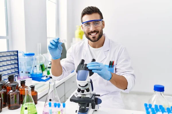 Young Hispanic Man Wearing Scientist Uniform Using Microscope Laboratory — Stock Photo, Image