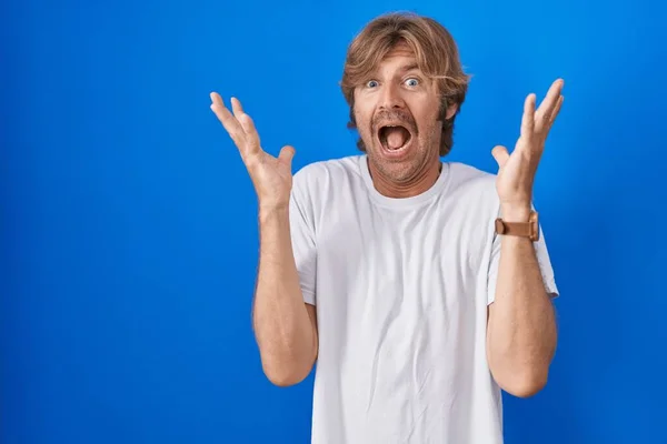 Hombre Mediana Edad Pie Sobre Fondo Azul Celebrando Loco Sorprendido —  Fotos de Stock