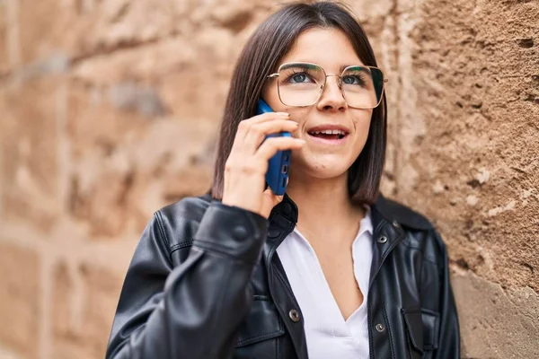 若いです美しいですヒスパニック女性笑顔自信を持って話して上のスマートフォン上の隔離された石の背景 — ストック写真