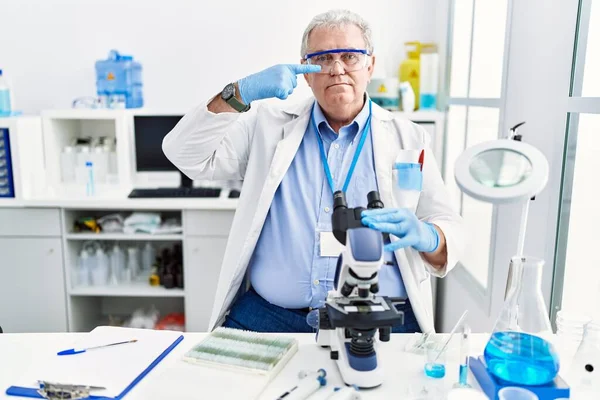 Starszy Biały Mężczyzna Pracujący Laboratorium Naukowym Wskazujący Palcem Twarz Nos — Zdjęcie stockowe