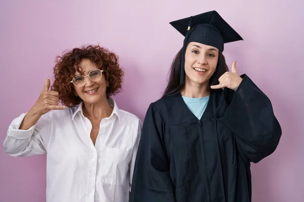 Spaanse Moeder Dochter Met Afstudeerpet Ceremonie Badjas Lachend Telefoongebaar Makend — Stockfoto