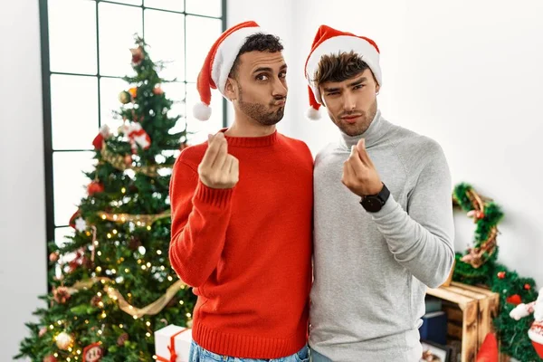 Genç Eşcinsel Çift Noel Ağacının Yanında Duruyor Şapka Takıyor Elleriyle — Stok fotoğraf