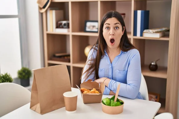 年轻的黑发女人吃东西时 带着家里的食物 吓得张大了嘴 惊慌失措的 难以置信的脸 — 图库照片