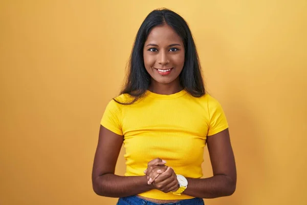 Jonge Indiaanse Vrouw Staat Gele Achtergrond Met Handen Bij Elkaar — Stockfoto