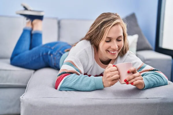 Mujer Rubia Joven Bebiendo Café Tumbado Sofá Casa — Foto de Stock