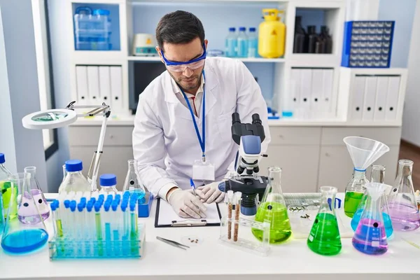 Jeune Homme Hispanique Scientifique Écrit Sur Document Laboratoire — Photo