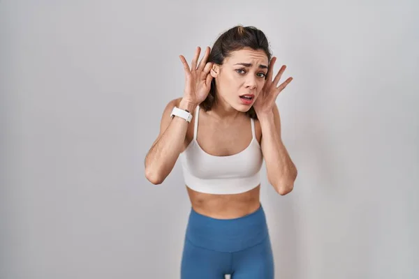 Hispanische Frau Sportkleidung Über Isoliertem Hintergrund Versucht Beide Hände Ohr — Stockfoto