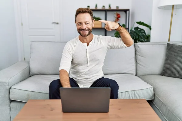 Hombre Mediana Edad Usando Ordenador Portátil Casa Sonriendo Apuntando Cabeza —  Fotos de Stock