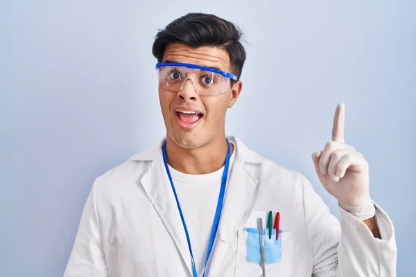 Homem Hispânico Trabalhando Como Cientista Apontando Dedo Para Cima Com — Fotografia de Stock