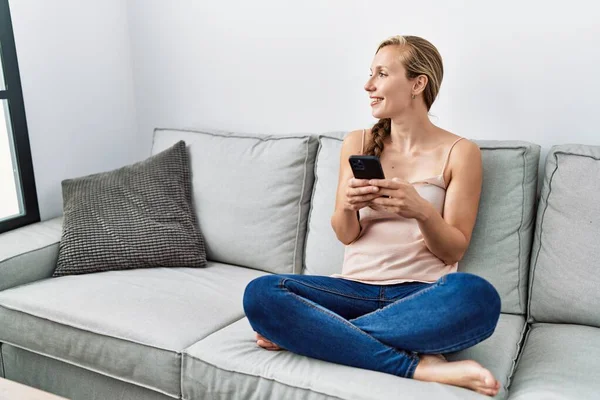 Young Caucasian Woman Using Smartphone Sitting Sofa Home — Zdjęcie stockowe