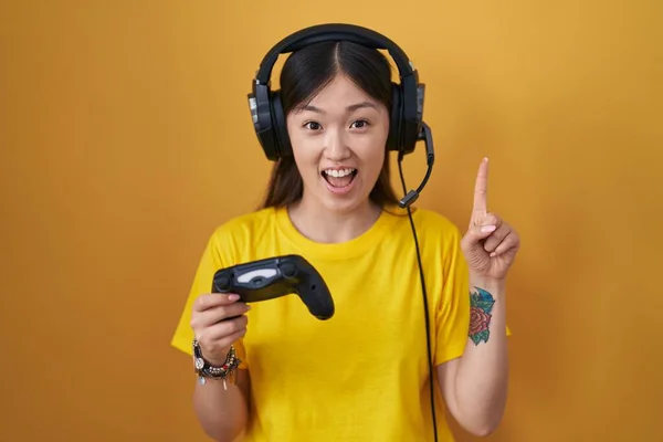 Jovem Chinesa Jogando Vídeo Game Segurando Controlador Sorrindo Espantado Surpreso — Fotografia de Stock