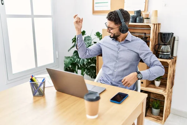 Young arab man smiling confident listening to music at office