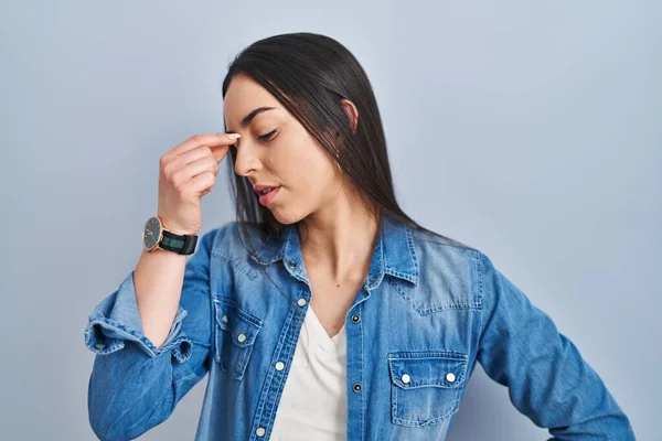 站在蓝色背景上的西班牙裔女人疲倦地揉揉鼻子和眼睛 感到疲倦和头痛 压力和挫败感概念 — 图库照片